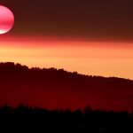 the sun is setting over a mountain range