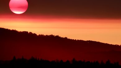 the sun is setting over a mountain range