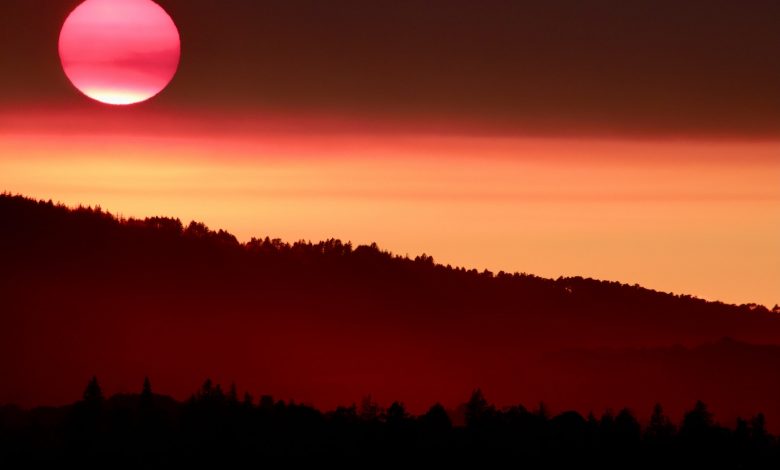 the sun is setting over a mountain range