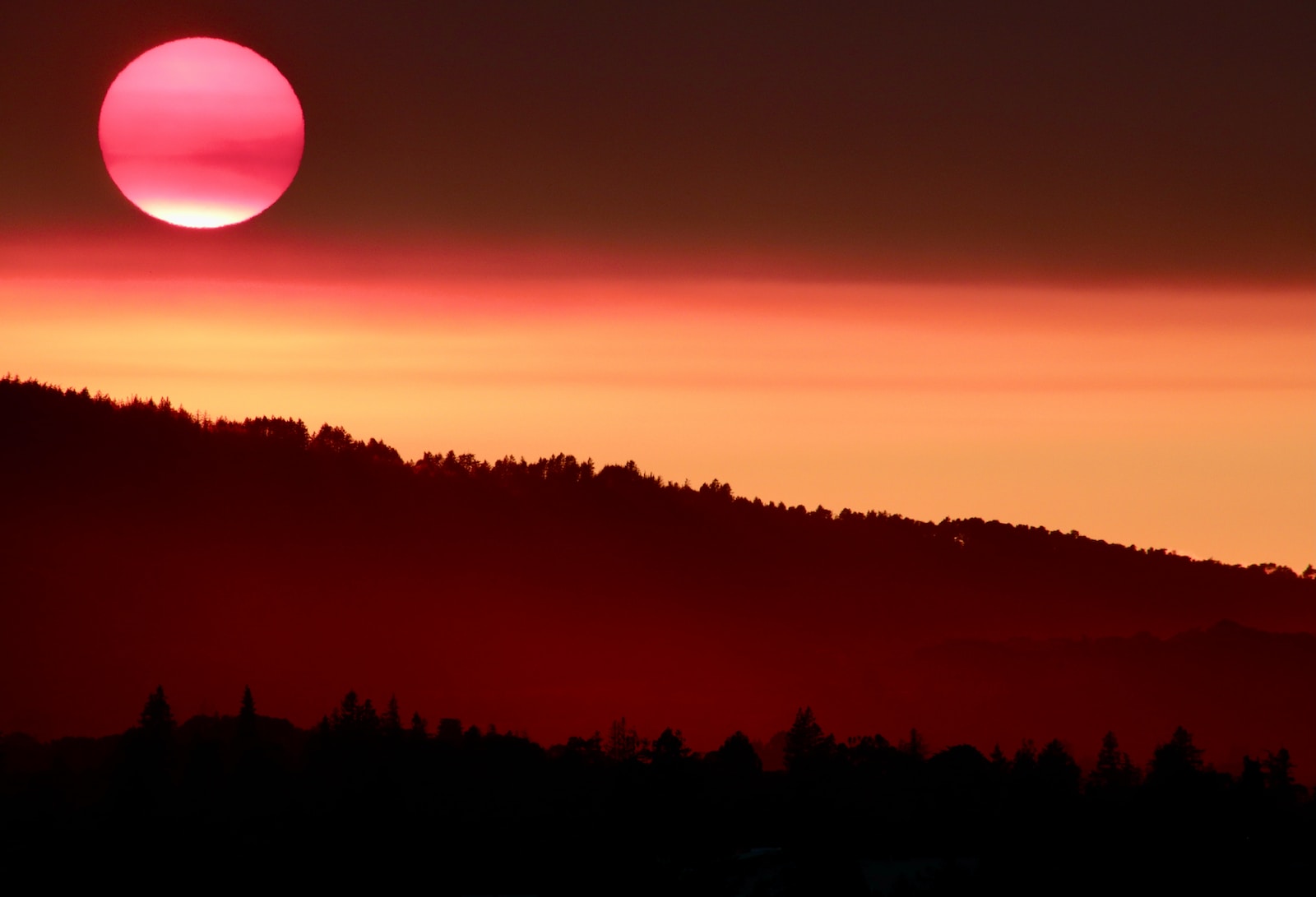 the sun is setting over a mountain range