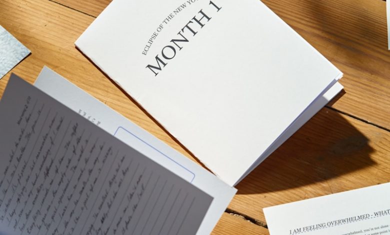 a table topped with lots of papers on top of a wooden table