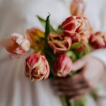 a woman holding a bouquet of flowers in her hands