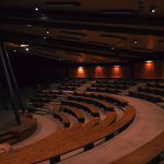 a large auditorium filled with lots of wooden seats