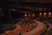 a large auditorium filled with lots of wooden seats