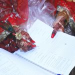a person holding a book with henna on their hands