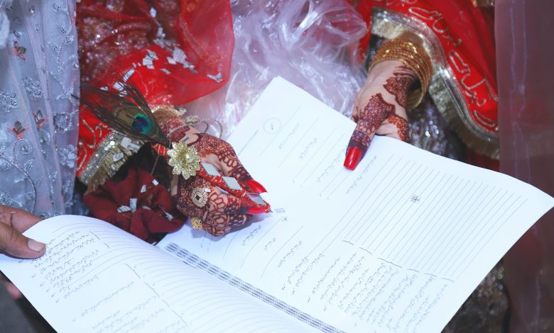 a person holding a book with henna on their hands