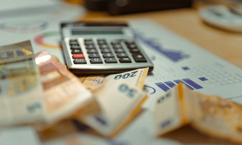A calculator sitting on top of a pile of money